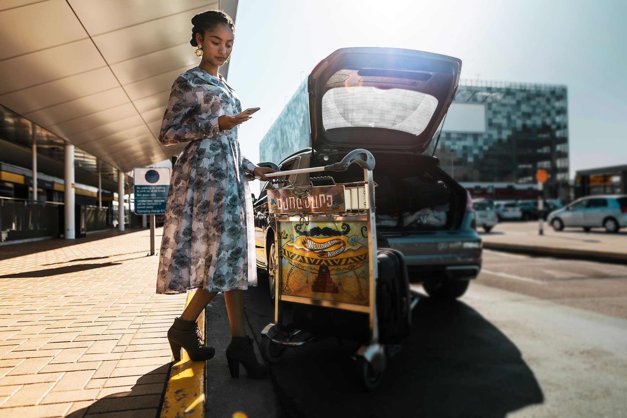 Woman at Wellington airport loading her bags into a Mevo Audi A3 e-tron